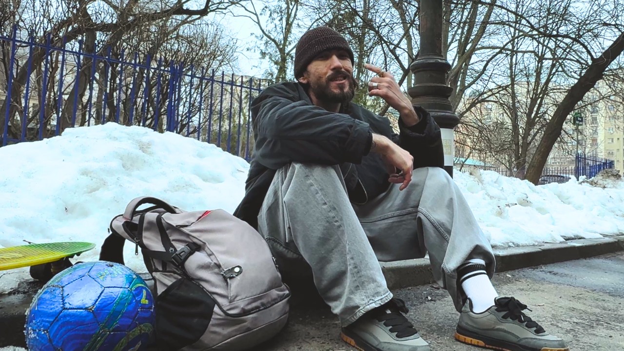 Pe aici — CEZIC stând în zăpadă lângă un rucsac